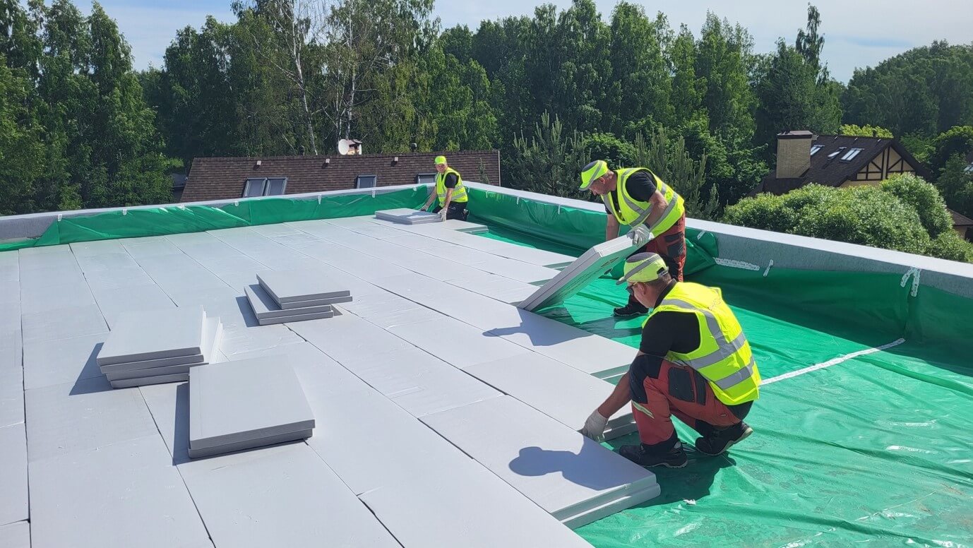 Укладка утеплителя на плоскую кровлю, кровельщики работают с плитами XPS